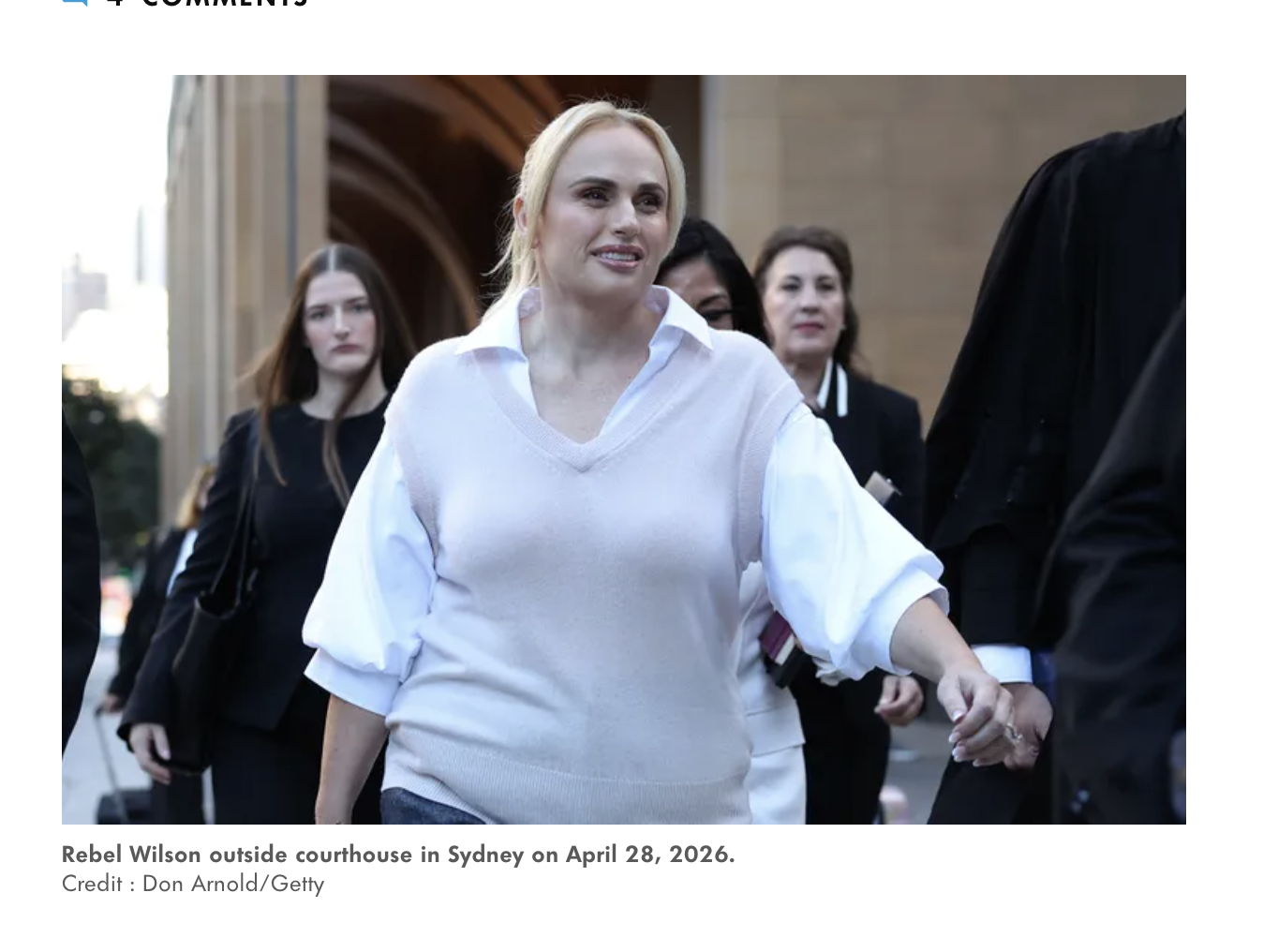 Rebel Wilson outside the Sydney courthouse on April 28, 2026, hair pulled back in a low ponytail, white knit top